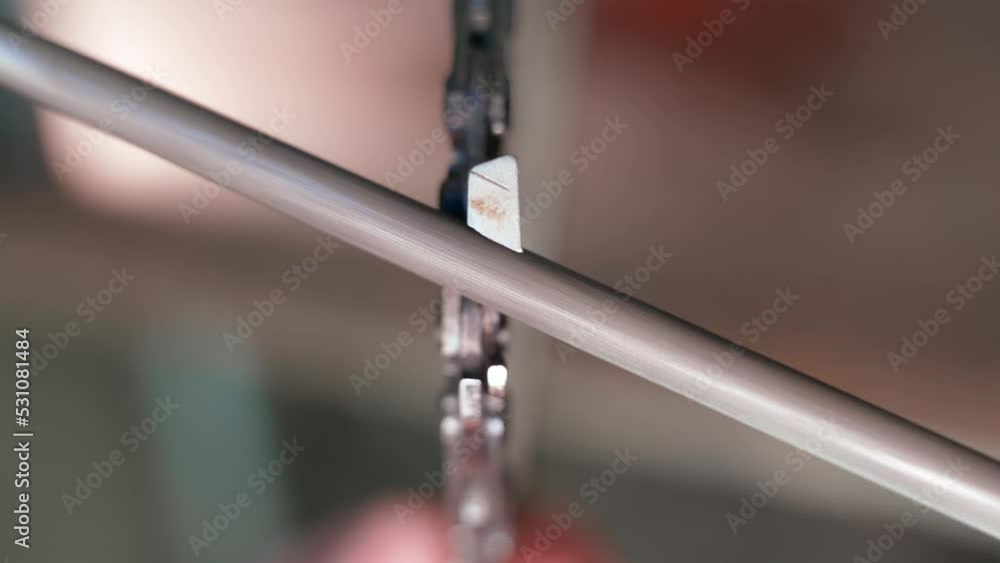 The chain of a chainsaw is sharpened with a round file closeup. Blunt