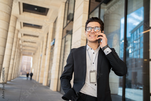 Talking on the phone. Confident businessman man with glasses in a business suit