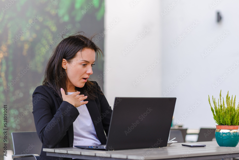 Impressed,shocked,surprised caucasian business woman student freelancer using laptop,watching comedy,reading news, surfing internet social media online in the city cafe outdoors. Impressed,shocked,surprised caucasian business woman student freelancer using laptop,watching comedy,reading news, surfing internet social media online in the city cafe outdoors.