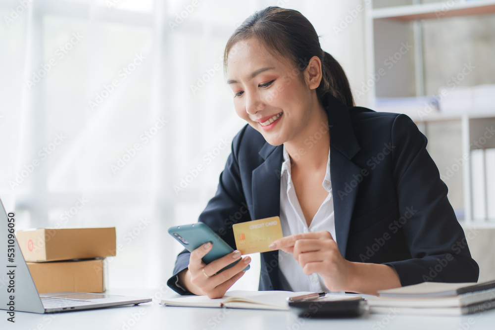 Happy asian Business woman pay online using mobile phone at the office. Happy asian Business woman pay online using mobile phone at the office.