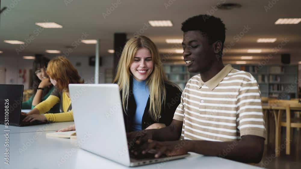 Young people studying together in the library - School education concept Young people studying together in the library - School education concept