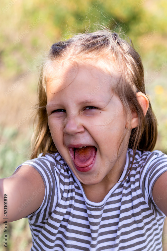 Smiling little girl in the park. Copy space. Happy child looking at the camera. Portrait of a laughing kid outside. Take a selfie Smiling little girl in the park. Copy space. Happy child looking at the camera. Portrait of a laughing kid outside. Take a selfie