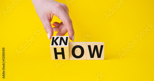 Know how symbol. Businessman hand turnes wooden cubes and changes word How to Know. Beautiful yellow background. Business and Know how concept. Copy space. photo