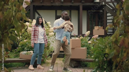 A multi-ethnic family is playing while moving into a new purchased house. African dad, Caucasian mom, son.Multiracial Family,Mixed Race,Diverse People,Multiethnic Relations