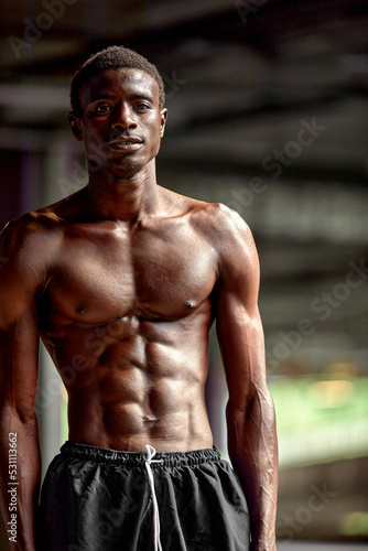 Handsome African American sportman standing on the street while taking break after training. Black male having rest after workout