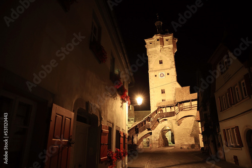 Ancient street with lit up medieval tower at night 