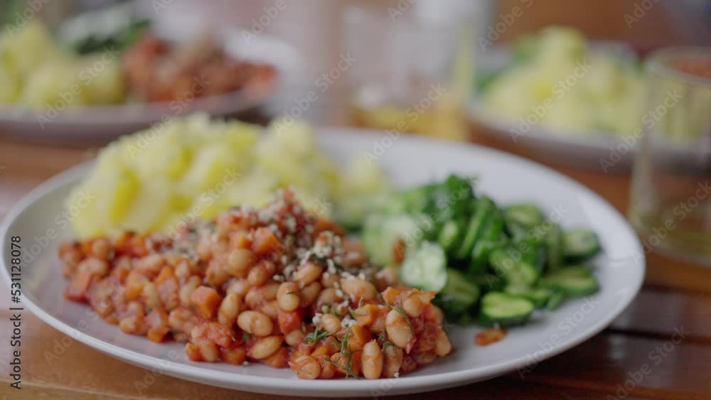 plate with beans, potatoes and salad, on the table. close-up. slow motion, vegan plate with beans, potatoes and salad, on the table. close-up. slow motion, vegan