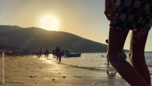 People enjoying their summer holiday on the beach during golden hour