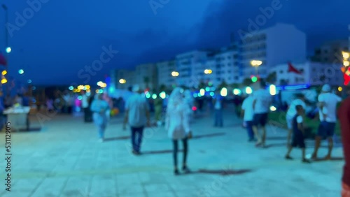 Blurred footage of People walking on the street on a foggy night photo