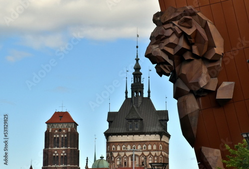 Altbautürme hinter einem modernen Löwen in Danzig