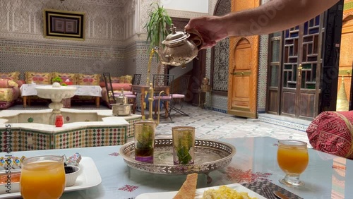 Man pouring mint tea into a Moroccan glasses