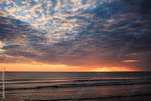 Coast of the Caspian Sea at sunset, pink-orange clouds, water, beach, summer. © Константин Чернышов