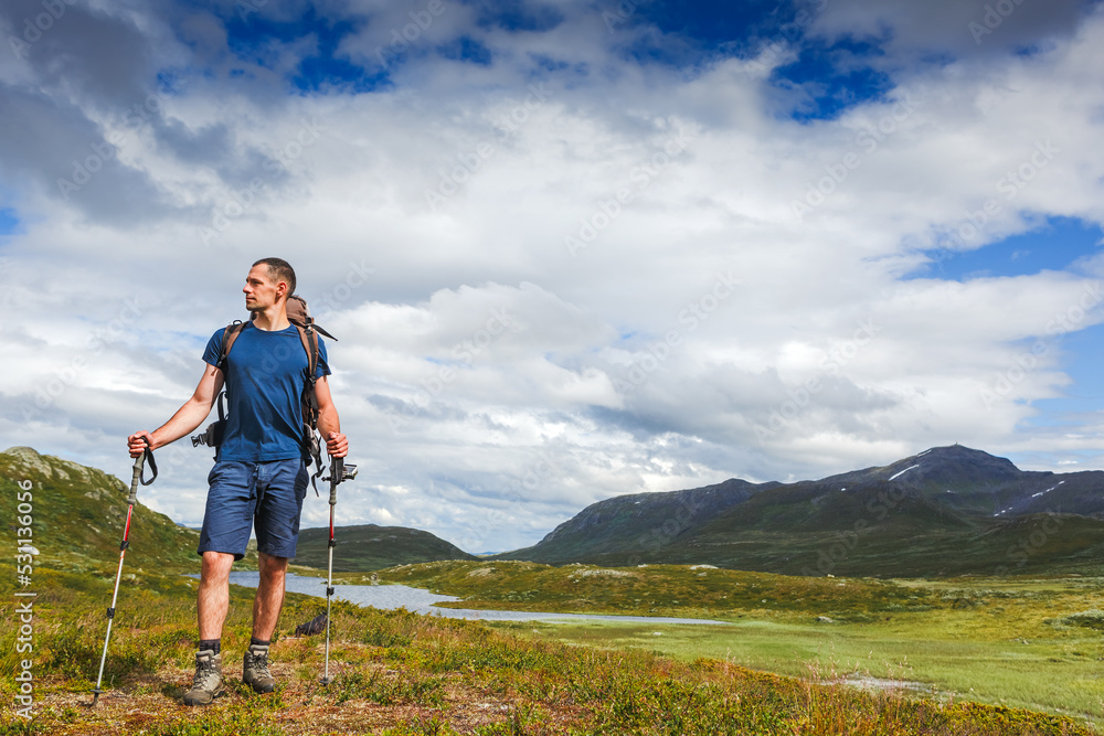 Hiker with backpack enjoying the view in Norway mountains