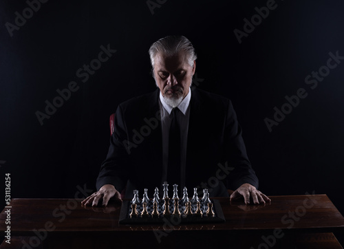 Photography grandmaster in a suit playing chess