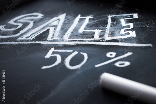 White chalk and word "sale" wrote with white chalk on blackboard 