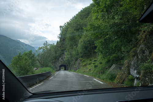 Kyrping, Norway - June 9, 2022: the old Akra Fjord road, POV from a Tesla Model 3 driving on the scenic route. Tunnel and bridges in a cloudy spring day. Selective focus