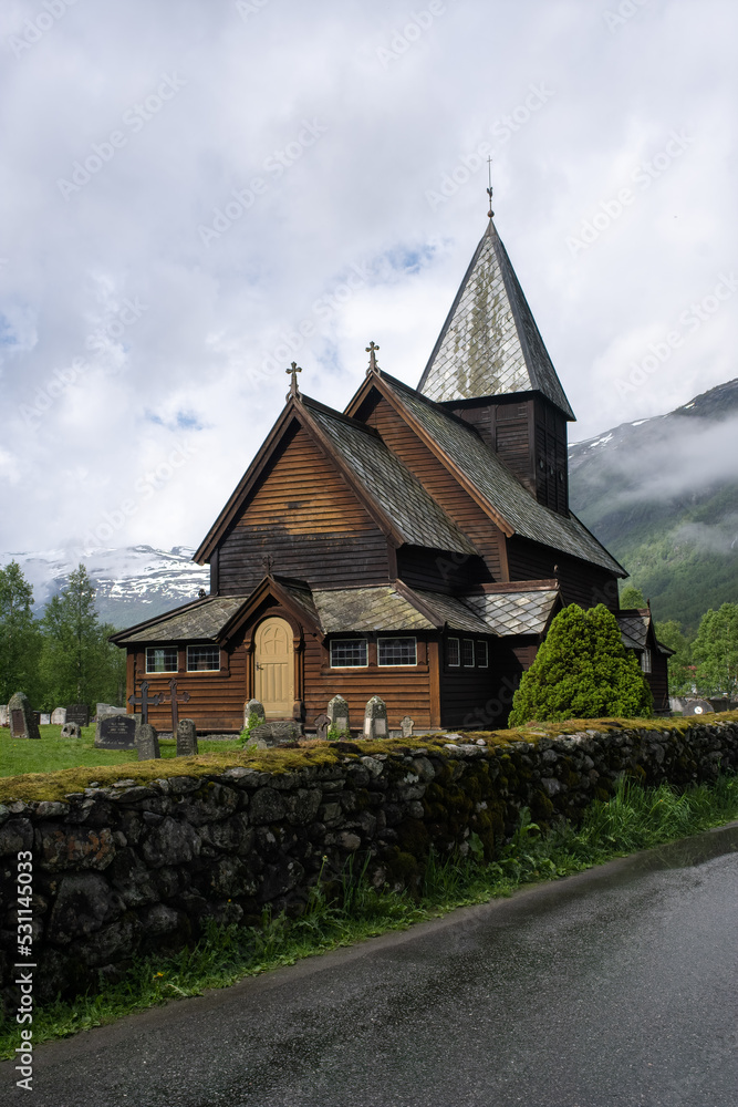 Roldal, Norway - June 11, 2022: Medieval graveyard and Roldal wooden stave church. Roldal Stavkirke, 13th century. It is a parish church of the Church of Norway. Cloudy spring day. Selective focus Roldal, Norway - June 11, 2022: Medieval graveyard and Roldal wooden stave church. Roldal Stavkirke, 13th century. It is a parish church of the Church of Norway. Cloudy spring day. Selective focus
