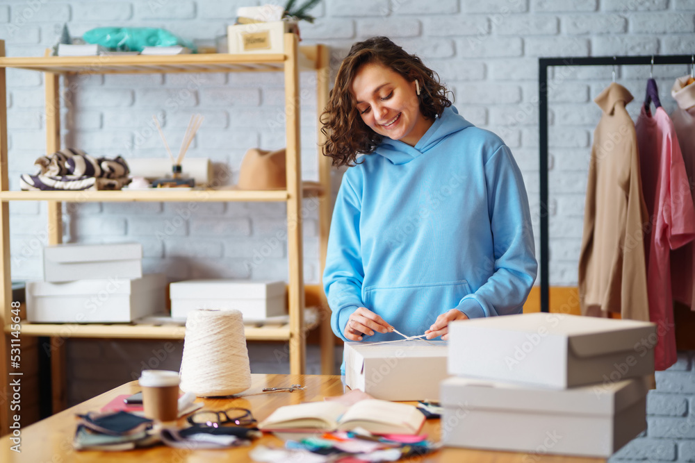 Young woman packing boxes to be shipped. Оnline store, small business owner, seller, entrepreneur, packing bag, mailbox. Young woman packing boxes to be shipped. Оnline store, small business owner, seller, entrepreneur, packing bag, mailbox.