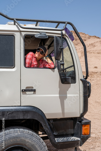 Woman in her truck camper in the middle of the desert.