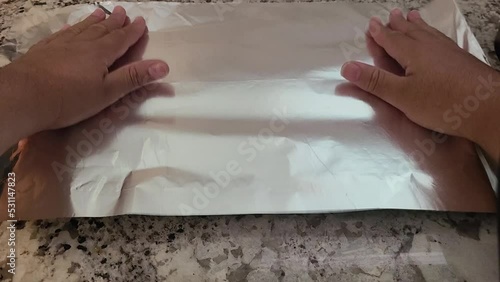 Placing aluminum foil on a pan photo