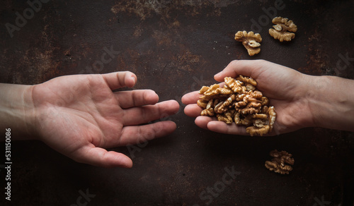 Foto conceptual de manos de personas compartiendo nueces sobre mesa rústica photo