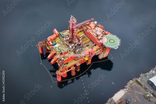 Schilderij op canvas Aerial view of an offshore oil drilling platform and maintenance dock in a fjord