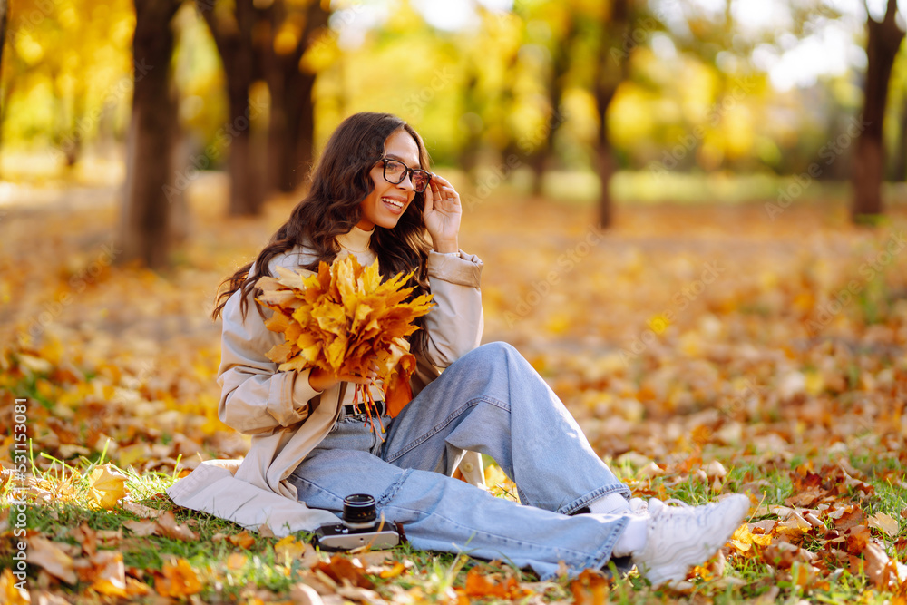 Portrait of beautiful woman taking pictures in the autumn forest. Smiling woman enjoying autumn weather. Rest, relaxation, lifestyle concept. Portrait of beautiful woman taking pictures in the autumn forest. Smiling woman enjoying autumn weather. Rest, relaxation, lifestyle concept.