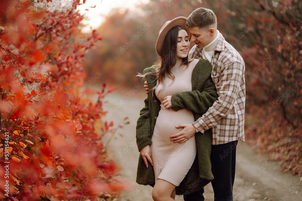 Happy and young pregnant couple in autumn park. People, lifestyle ...