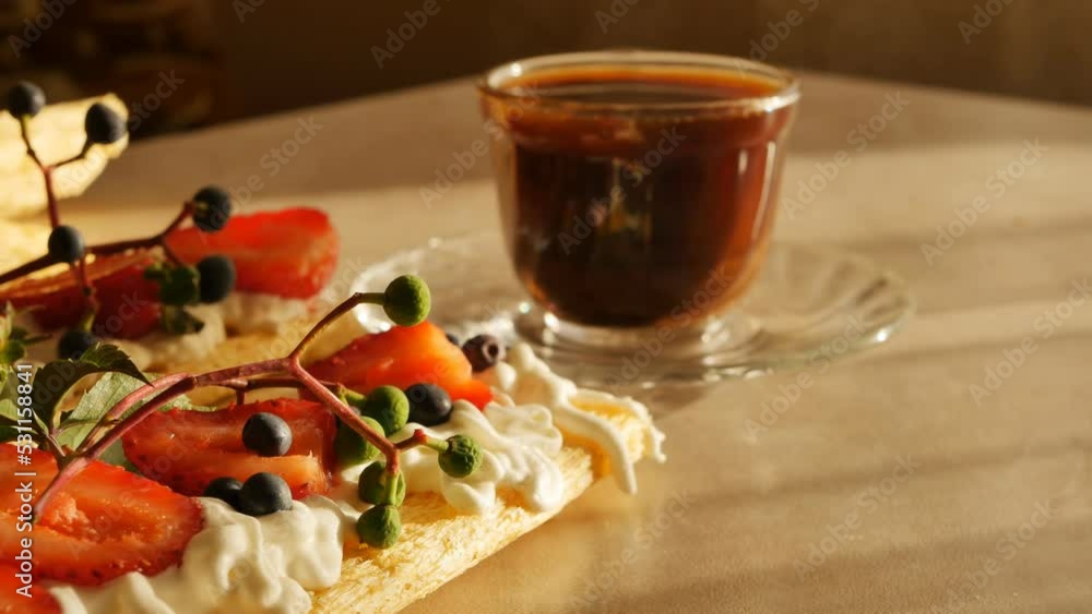 pour a drink into a cup of coffee and have breakfast with crispbread sandwiches, whipped cream and fresh strawberries and blueberries close-up, dollie shot. Healthy breakfast of cereals and berries pour a drink into a cup of coffee and have breakfast with crispbread sandwiches, whipped cream and fresh strawberries and blueberries close-up, dollie shot. Healthy breakfast of cereals and berries