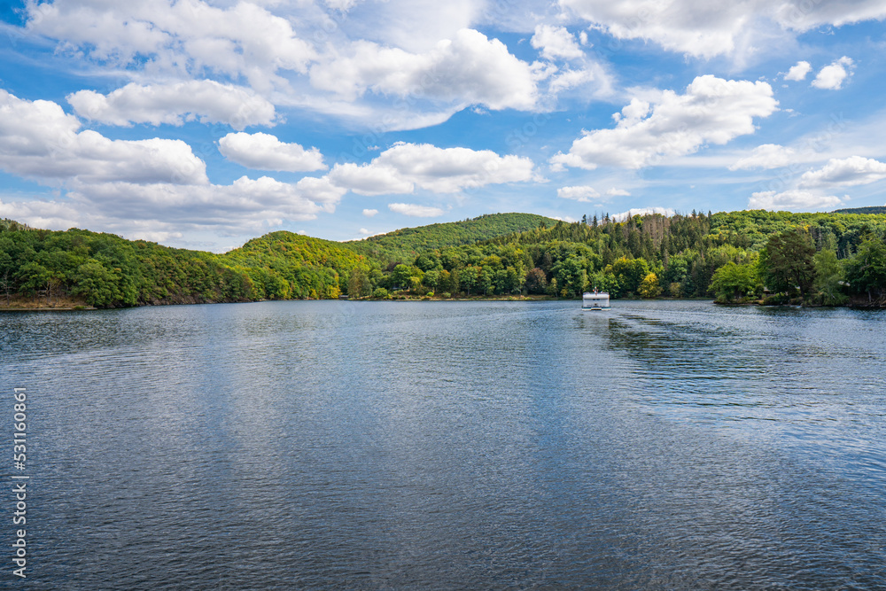 Boat with tourists on Lake Rursee, In the middle of the Eifel National Park, surrounded by unique natural scenery and unspoilt nature Boat with tourists on Lake Rursee, In the middle of the Eifel National Park, surrounded by unique natural scenery and unspoilt nature