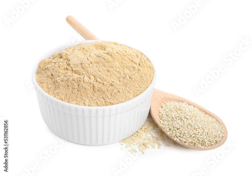 Fototapeta Naklejka Na Ścianę i Meble -  Sesame flour in ceramic bowl and spoon of seeds isolated on white