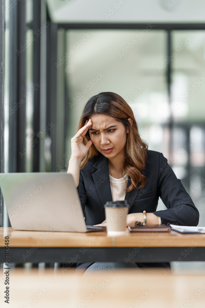 © Phushutter - Stress asian business woman after working hard at office workplace. © Phushutter - Stress asian business woman after working hard at office workplace.