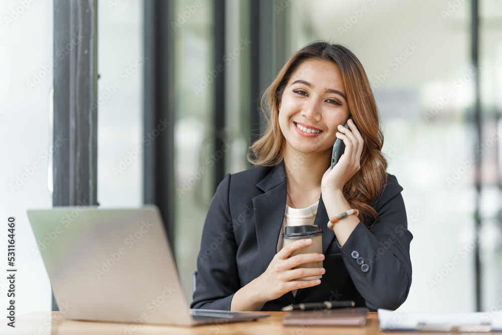 Beautiful asian business woman talking on mobile phone, feeling happy at office workplace. Beautiful asian business woman talking on mobile phone, feeling happy at office workplace.