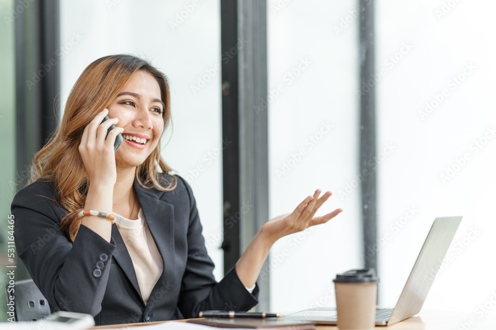 Beautiful asian business woman talking on mobile phone, feeling happy at office workplace. Beautiful asian business woman talking on mobile phone, feeling happy at office workplace.