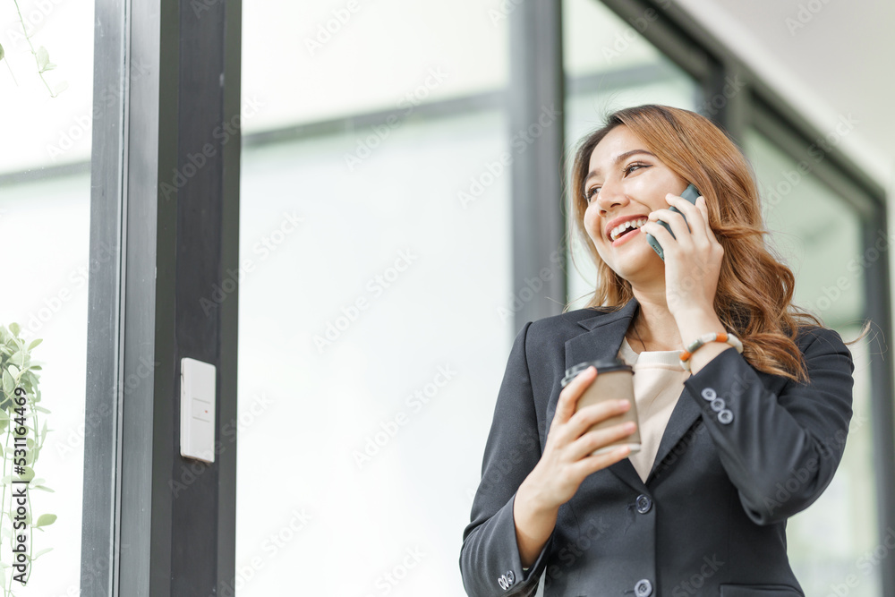 Beautiful asian business woman talking on mobile phone, feeling happy at office workplace. Beautiful asian business woman talking on mobile phone, feeling happy at office workplace.