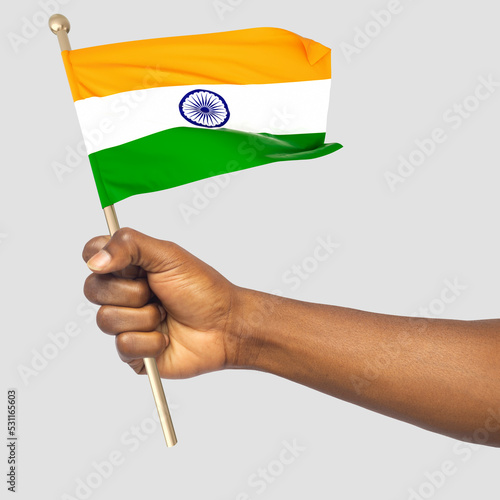 Hand holding Indian national flag isolated on white background photo