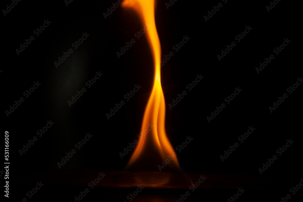 Flames in dark. One flame on black background. Ignition details. Fire burns yellow.