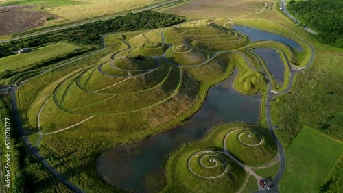 Smooth drone shot above the gentle hills and water of Northumberlandia photo