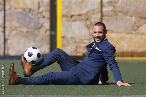 Businessman playing soccer ball.