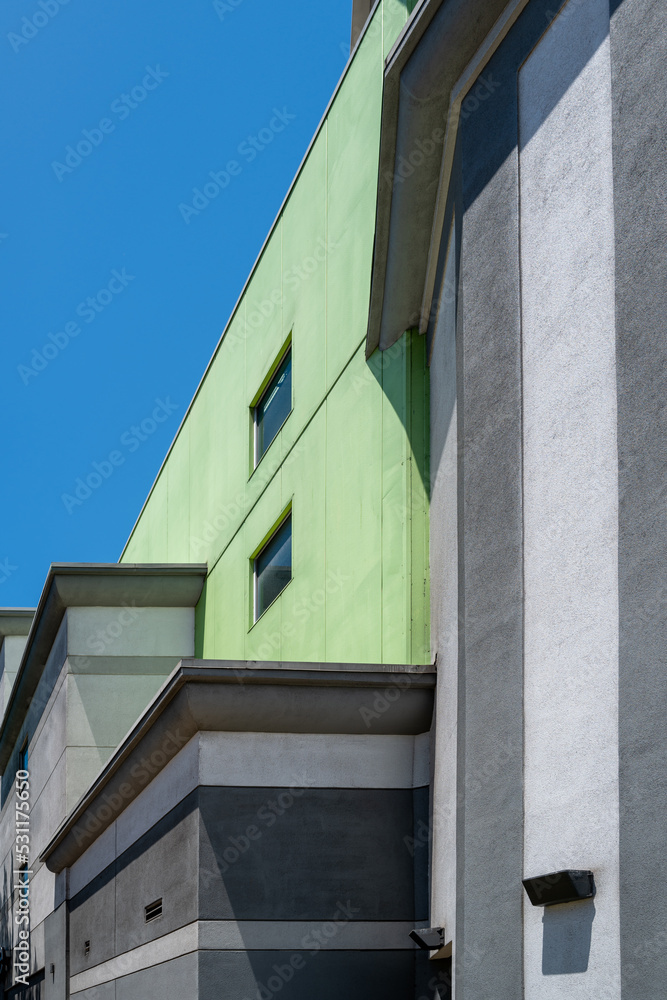 PROFILE SIDE VIEW OF A GREEN, CHARCOAL GRAY, AND SILVER ABSTRACT WALL.