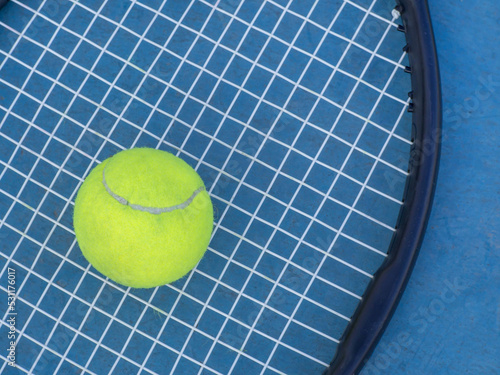 Tennis ball and racket on blue court © wor_woot