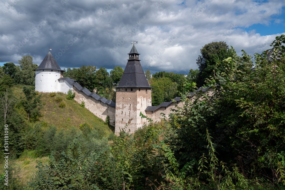View of the wall of the Holy Dormition Pskov-Pechersk Monastery, the Tower of the Upper Lattices, Tailovskaya tower on a sunny summer day, Pechory, Pskov region, Russia