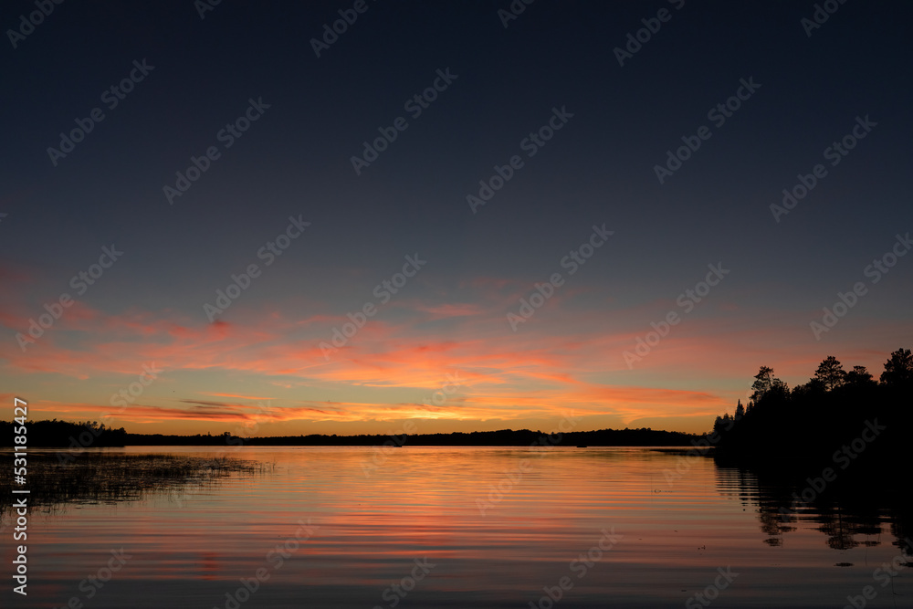 Fading sunset glow at dusk over northern lake scene for magazine newsletter advertising layout design