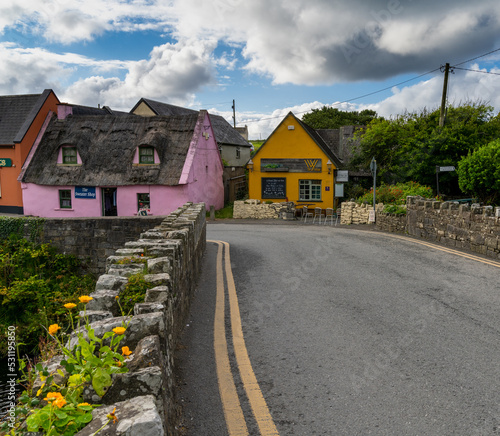 bridge leads to colorful houses in the old village center of Doolin photo