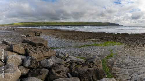 panorama view of the glaciokarst coastline at Doolin Harbor with the Cliffs of Moher in the background
