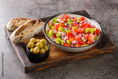 Trampo is a typical peppers tomatoes salad in Majorca Spain closeup on the wooden board on the table. Horizontal photo