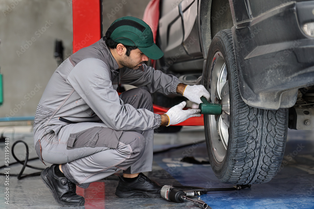 Mechanic changing a wheel of a modern car Mechanic changing a wheel of a modern car