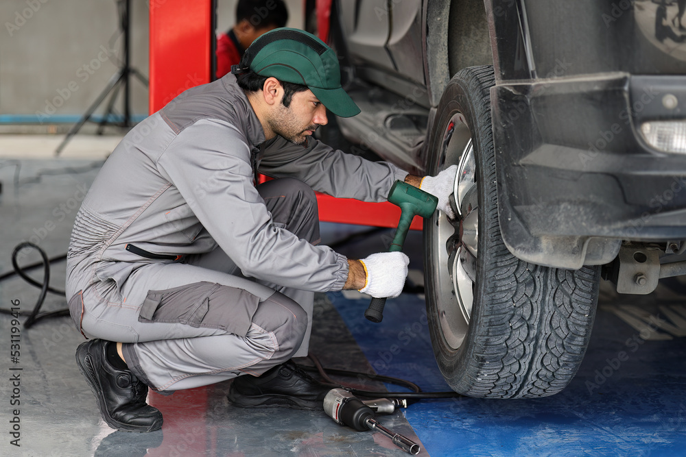 Mechanic changing a wheel of a modern car Mechanic changing a wheel of a modern car