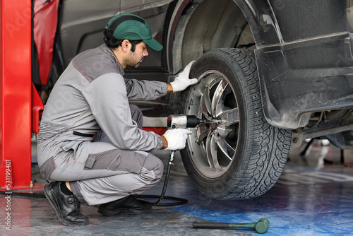 Mechanic changing a wheel of a modern car