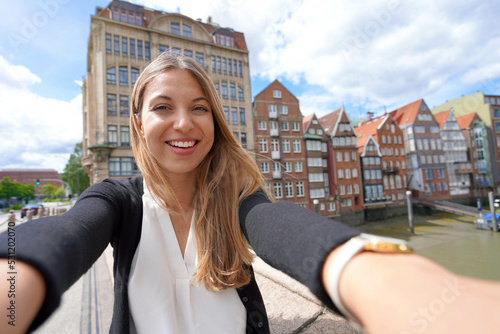 Beautiful young woman taking selfie photo with smartphone in Hamburg, Germany photo